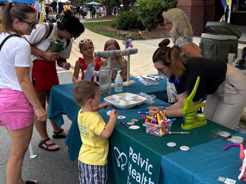 Image shows people talking at a table at an outdoor event